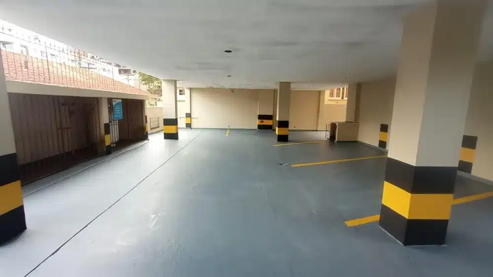 Garagem depois do Sistema Parking 3.0: piso cinza selado com demarcação amarela